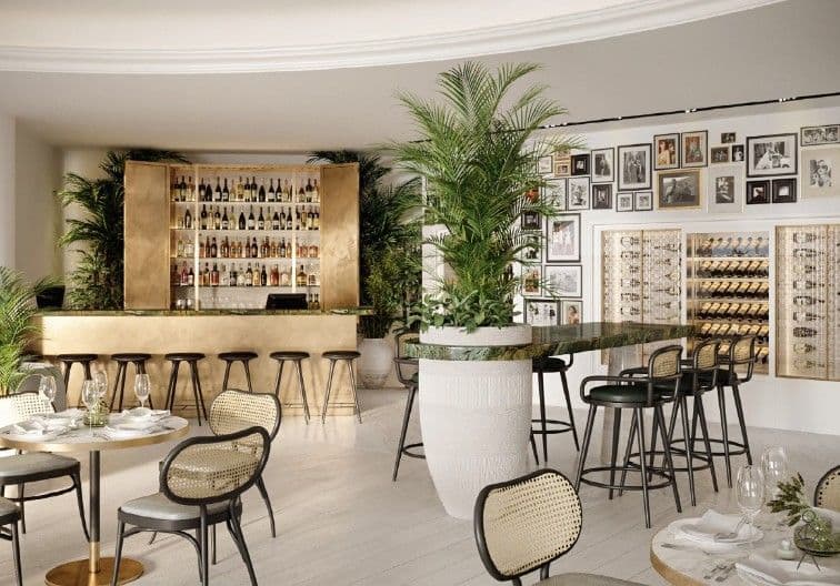 Stylish hotel bar with seating, wine display, and modern dining area surrounded by greenery
