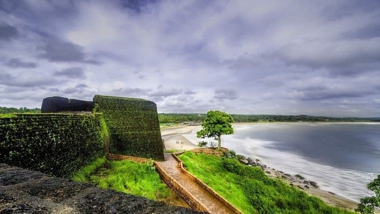 Fort walls with pathway leading to ocean view and greenery