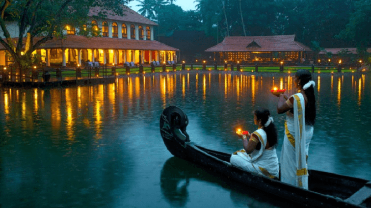 Woman wearing traditional saree holding a diya on a boat celebrating Onam festival